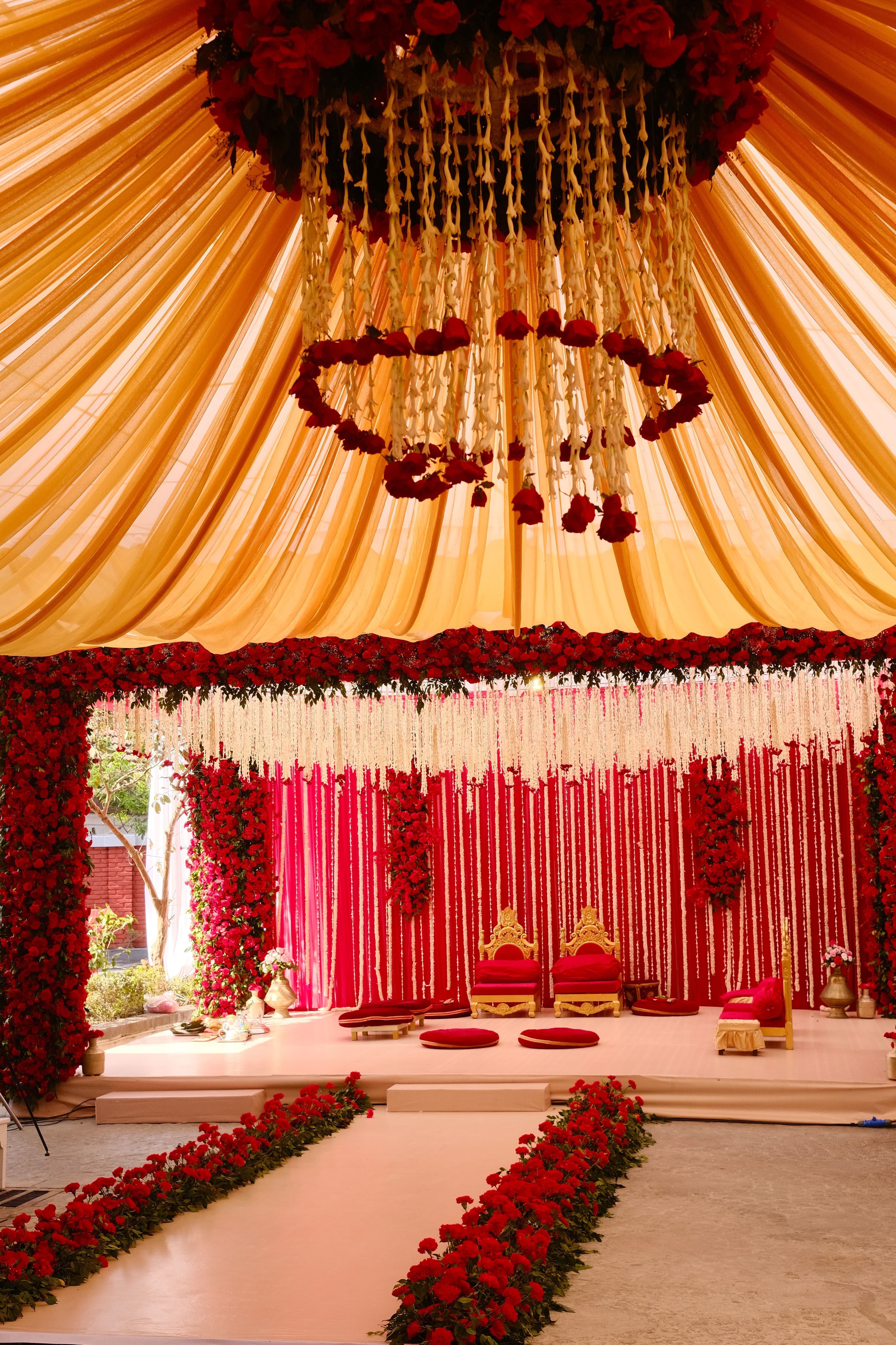 Wedding mandap decorated with red roses and hanging flowers